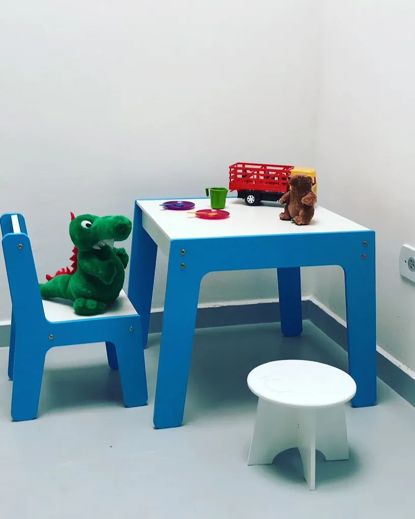 Cantinho infantil da Qualidente, com mesinha azul e brinquedos para as crianças